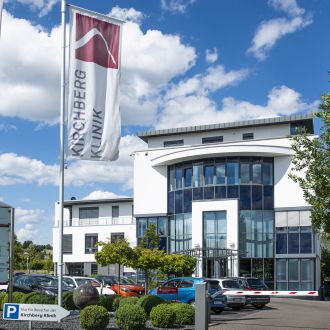 Kirchberg Klinik - Ihr Zahnarzt Aachen - Außenansicht des Gebäudes mit Fahnen