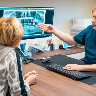 Patientenberatung für ein Implantat durch Dr. Markus Keiner am PC